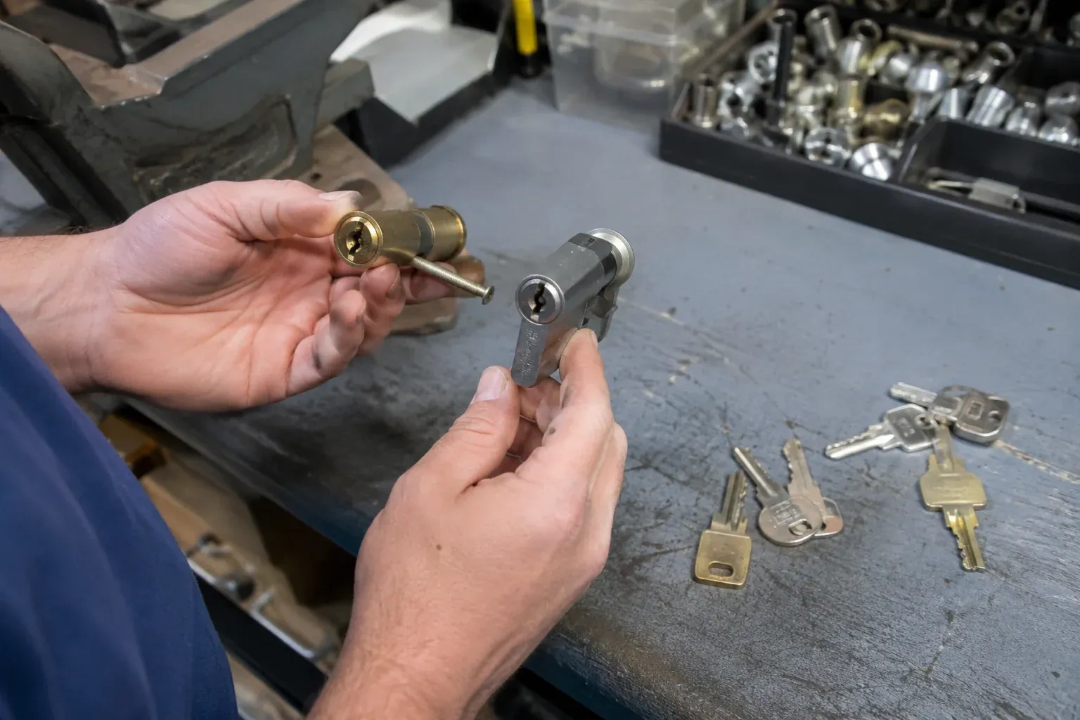Hands comparing detached lock cylinders beside loose keys on a workbench. — Broken Key Extraction, Fort Erie